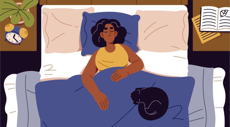 Woman lying in bed with eyes shut wearing a yellow vest. Blue duvet, white sheets, one blue and two beige pillows. A book, plant,alarm clock on the bedside tables and a black cat curled up on the bed.