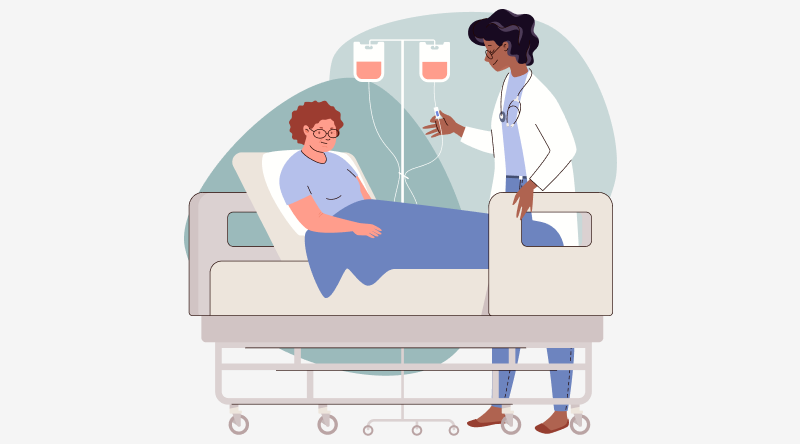 A woman sits up in a hospital bed. She's covered by a blue blanket. A drip stand with two drip bags containing blood is beside the bed. A woman wearing a white doctor's coat is stood by the bed.